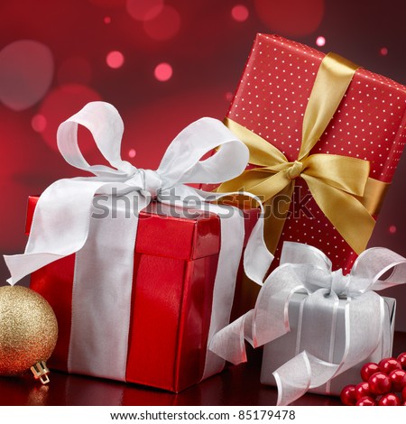 christmas presents and ornaments against red bokeh lights background