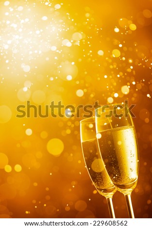 two glasses of champagne against gold bokeh background