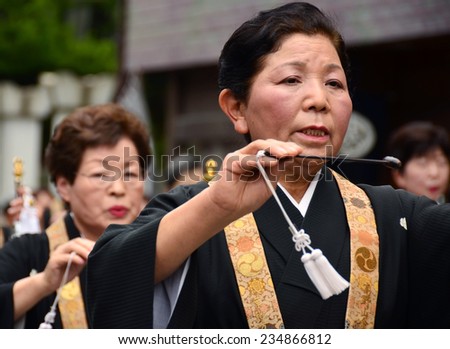 Koya, Japan - June 14,2011: Woman in formal buddhist attire dancing and chanting during Aoba festival, an annual event celebrating the birthday of Kobo Daishi, a renowned Buddhist saint