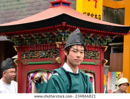 Koya, Japan - June 14, 2011: Young man in formal Shinto priest attire marching with a floating shrine during Aoba festival, an annual event celebrating the birthday of Kobo Daishi