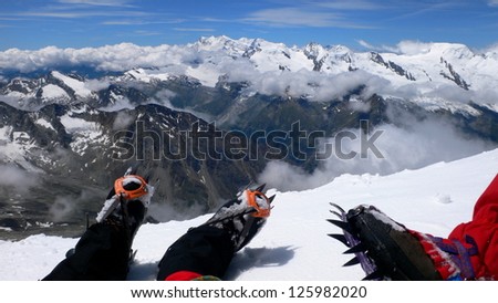 Relaxed and enjoying the views in Weissmies mountain\'s summit after a long climbing, the Alps, Switzerland