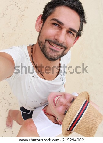 Young couple taking a self picture close to the sea in the southern beach of \