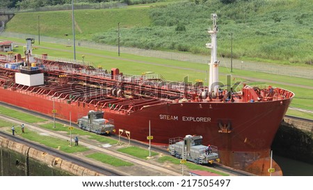 Miraflores locks, Panama - August 5th of 2014: Red large cargo ship entering Miraflores Locks, where vessels are lifted (or lowered) 54 feet (16.5 m) allowing them to go from Pacific to Caribbean Sea.