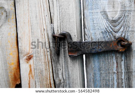 Forged old metal hook attached to the wooden door.