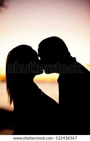 Silhouette of an engage couple kissing in the sunset at Micro Beach, Saipan