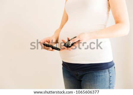 Pregnant woman checking blood sugar level. Gestational diabetes. Pregnancy health