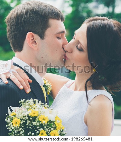groom and bride hug and kiss