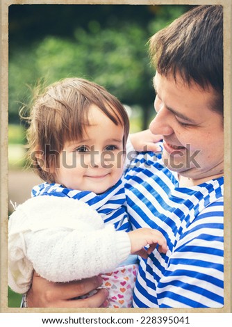 father playing with baby on nature black and white vintage card