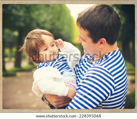 father playing with baby on nature black and white vintage card