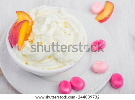 Whipped cream with peach fruits and candies dessert