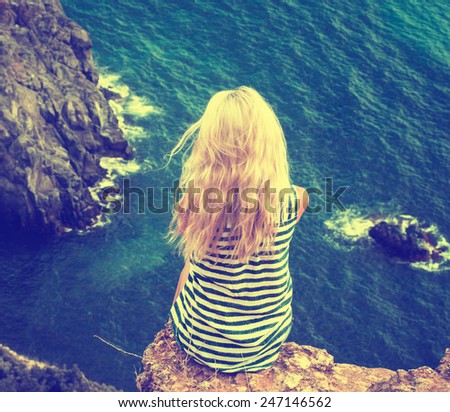 Woman back sitting near sea alone
