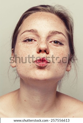 Portrait of fun attractive girl woman with freckles clear skin and beautiful hair kiss