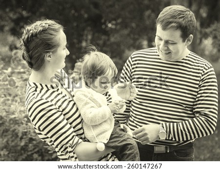 Family with child father and mother in same stripes clothes vintage black and white nature