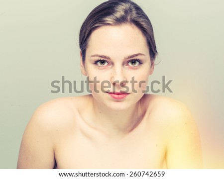 young beautiful woman with freckles portrait studio on light background hipster