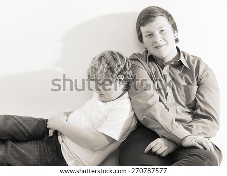 two boys brothers friends  studio portrait on white background playing black and white