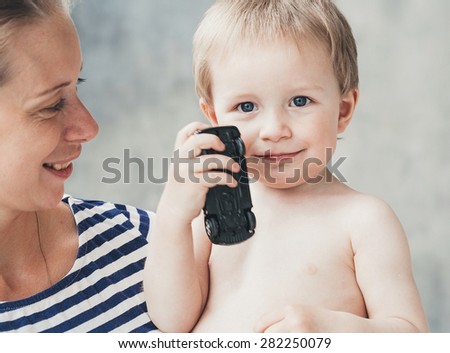 Family mother with son boy in same striped fashion clothes  on grey wall background