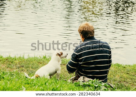 Cute dog funny Jack-Russell-terrier nature with man sitting near water together