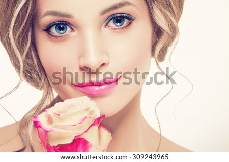 Beautiful woman portrait with perfect make up pink lips and nails blue eyes and rose flower