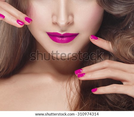 Beautiful woman young face with pink lips and pink manicure
