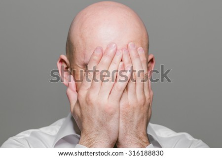Bald man face closed hands