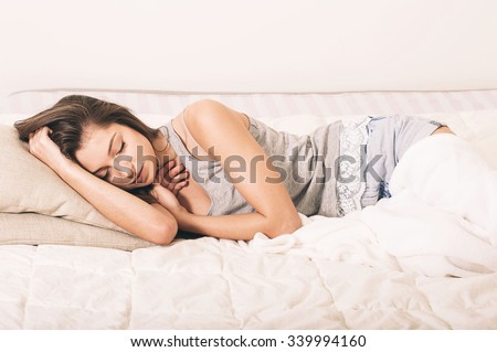 Young woman portrait in bedroom on bed alone relaxing
