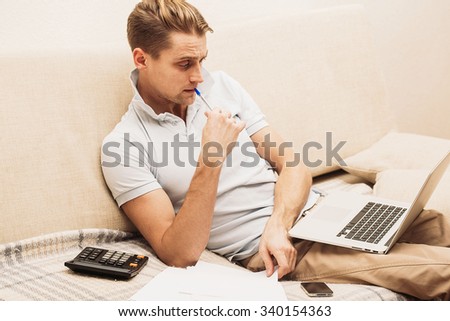 Man with laptop on sofa at home work