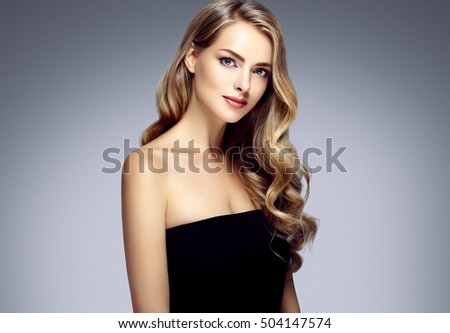 Amazing woman portrait. Beautiful girl with long wavy hair. Blonde model with hairstyle