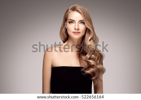Amazing woman portrait. Beautiful girl with long wavy hair. Blonde model with hairstyle