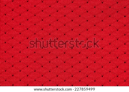 Red sportswear fabric with holes texture closeup photo background.