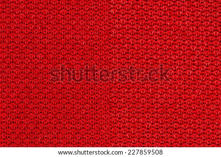 Red sportswear fabric texture closeup photo background.