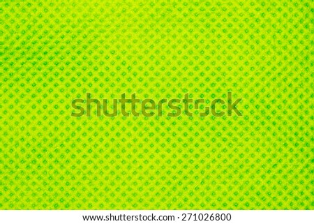 Green dotted synthetic fabric texture closeup photo background.