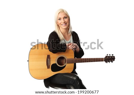 Young singer-songwriter sitting down with an acoustic guitar. White background.