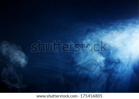 Billowy smoke and fog patterns lit by a beam of light