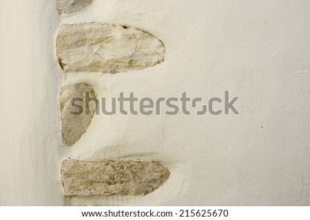 Plain wall with large stones inlayed into the material. Simple Background texture. Image taken in Halki, Naxos, Greece