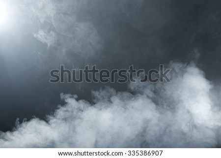 Fluffy white and grey steam on a dark background