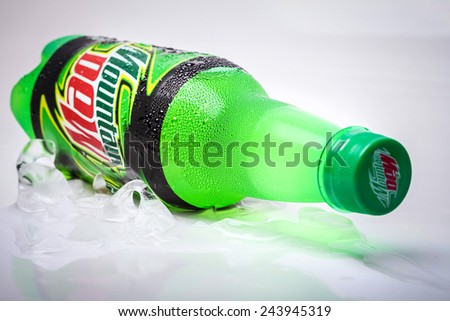 SABAH, MALAYSIA - january 13, 2015: Bottle of Mountain Dew drink on ice isolated on white. Mountain Dew citrus-flavored soft drink produced by PepsiCo. Mountain Dew was introduced in 1940
