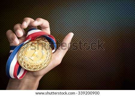 hand holding up a gold trophy cup as a winner in a competition