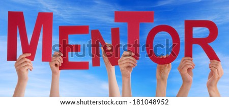 Hands Holding the Word Mentor in front of a blue Sky