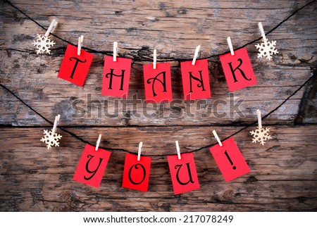 Thank You on Red Tags Hanging on a Line in front of a wooden Background