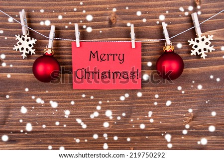 The Words Merry Christmas on a Red Label Hanging on a Line in the Snow