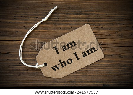 Close Up Of A Brown Label With White Ribbon On Wooden Background With English Life Quote I Am Who I Am Frame And Vintage Or Retro Style