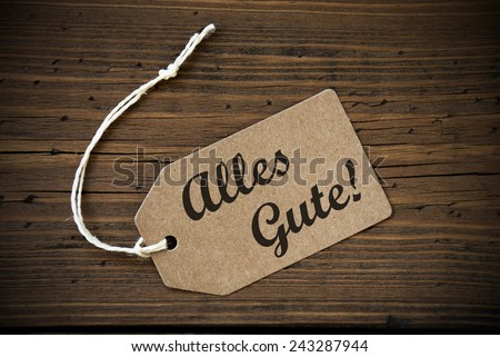 Close Up Of A Brown Label With White Ribbon On Wooden Background With German Text Alles Gute Frame And Vintage Or Retro Style