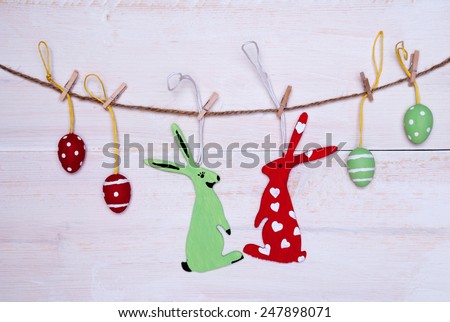 Couple Easter Bunnies Female Red Easter Bunny With Hearts Hanging On A Line With Two Red And Two Green Easter Eggs Which Are Dotted And Striped On White Wooden Vintage Background For Happy Easter