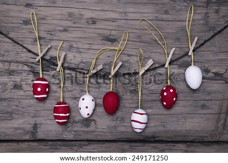 Many Red And White Easter Eggs Hanging On A Line Which Are Dotted And Striped On Brown Wooden Vintage Or Rustic Background For Easter Greetings And Happy Easter