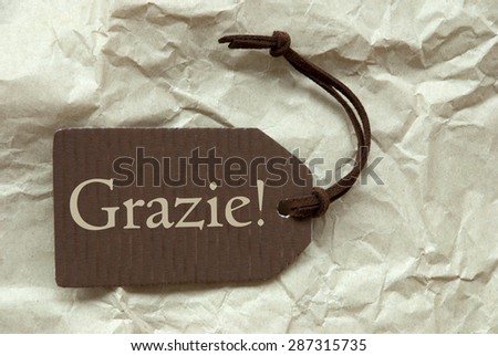 One Brown Label Or Tag With Brown Ribbon On Crumpled Paper Background With Italian Text Grazie Means Thank You Vintage Or Retro Style