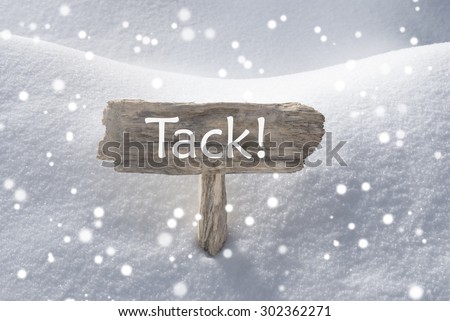 Wooden Christmas Sign With Snow In Snowy Scenery. Swedish Text Tack Means Thank You For Seasons Greetings Or Christmas Greetings. Christmas Atmosphere With Snowflakes