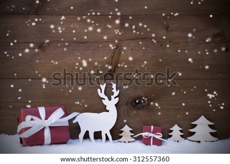 Christmas Decoration With Red Gifts Or Presents Moose Or Reindeer And Christmas Trees On Snow. Card For Seasons Greetings. Copy Space For Advertisement. Snowflakes Infront Wooden Background