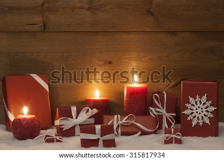 Christmas Decoration With Red Candles, Handmade Christmas Gifts, Presents,Snowflake, Snow. Peaceful Atmosphere With Candlelight For Gift Giving. Wooden Background For Copy Space. Vintage Rustic Style