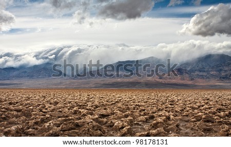The salt formations at Devils Golf Course in Death Valley National Park.  A storm rolls in over the mountains in the distance.
