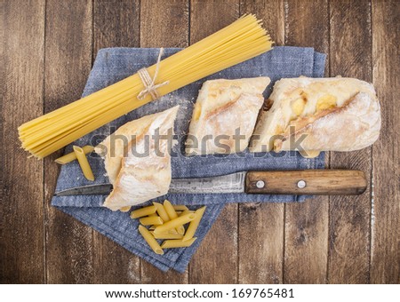 Pasta and bread on wooden background